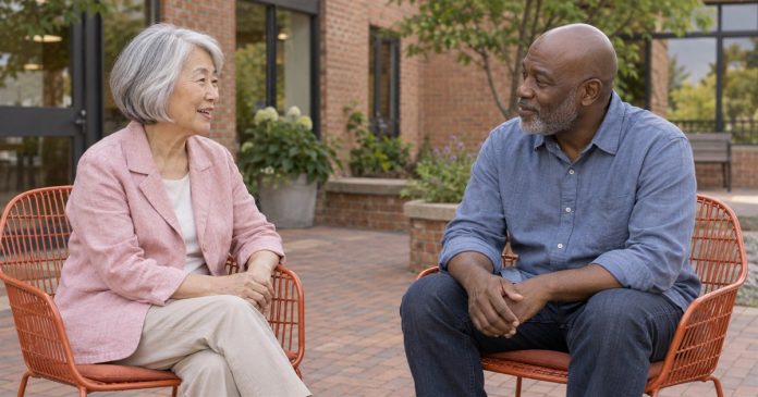 Two adults talking on orange chairs in a brick community patio